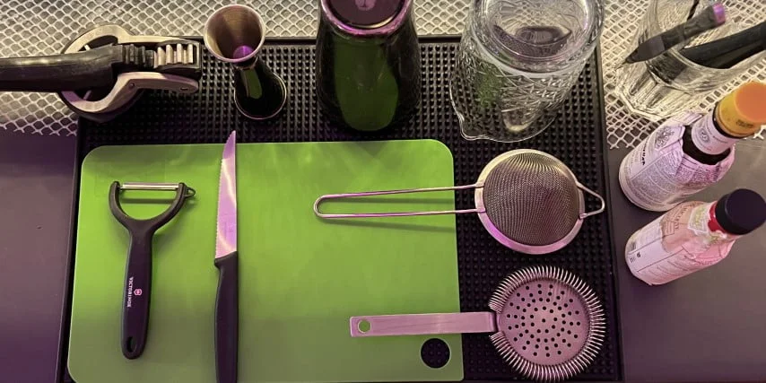 stacja barowa na której widać shaker barmański, miarke barmańską, sitko barmańskie, sitko fine strainer, szklanice barmańską, nóż i deske do owoców